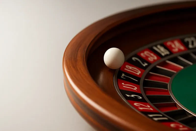 Roulette ball frozen mid-roll on wheel rim with blurred numbers